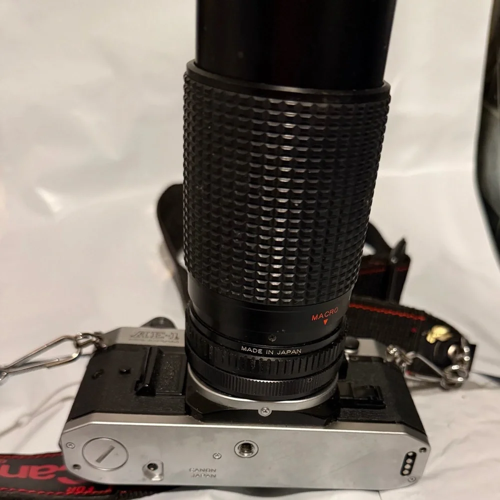 Canon silver and black SLR camera with black telephoto lens